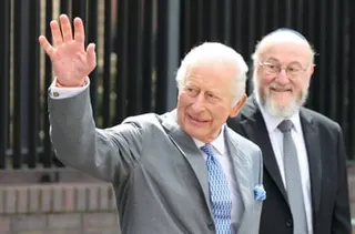King Charles, waving, with chief rabbi Sir Ephraim Mirvis.