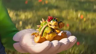 Super Mario Galaxy Movie trailer screenshot showing a shrunken Bowser sitting in Luigi's hand