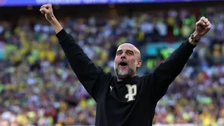 Manchester City boss Pep Guardiola celebrates with arms aloft on the touchline