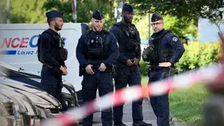 Getty Images Four uniformed French police stand in front of a row of cars, with a police tape in the foreground, near the scene of the shooting of three boys in the city of Nantes.