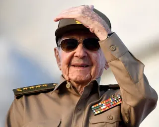 a man in military uniform shields his eyes with his hand