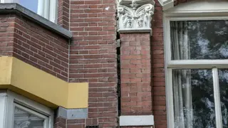 一棟房屋的磚造外牆上出現了一道明顯的大裂縫，從外觀可見結構已受到嚴重影響