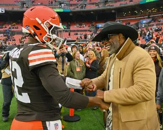 Shedeur Sanders greets his father Deion at a December 2025 Browns game.