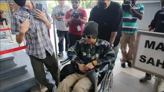 黄明志坐轮椅现身法庭 毒品案获判无罪释放