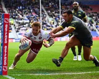 Ryan Hall of Leeds fails to stop Adam Keighran of Wigan from scoring a try