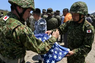 Japan Ground Self-Defence Force soldiers fold a US flag during a Balikatan drill in the Philippines on May 6. Photo: Reuters