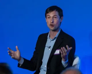 Reed Jobs speaks on stage at the LifeArc Translational Science Summit before an audience