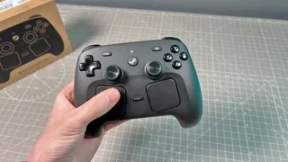 The Steam Controller on a desk during a teardown, with various parts removed.