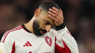 Mohamed Salah holds his hand on his head as he walks off the pitch following Liverpool's loss at Aston Villa