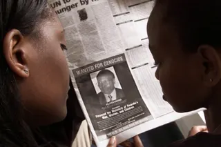Readers look at a newspaper in Nairobi in June 2002 carrying the photograph of Felicien Kabuga. Photo: Reuters