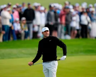 Scottie Scheffler watches his shot on the 10th green during a challenging second round at Aronimink