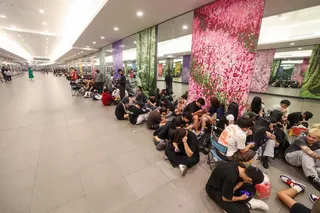 在滨海湾金沙斯沃琪门店外排队的约140名消费者席地而坐，耐心等候开业。（吴先邦摄）