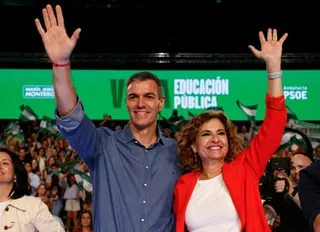 Sánchez and Montero smile as they wave to the crowd at the rally