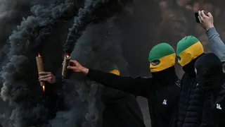Nantes' supporters holding smoke flares attempt to invade the pitch during the French L1 football match between FC Nantes and Toulouse