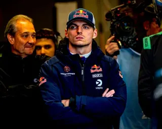 Max Verstappen stands arms folded.