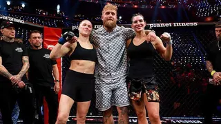 Jake Paul stands in between Ronda Rousey and Gina Carano