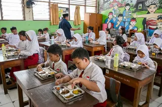 Elementary schoolchildren eating food prepared by the government's free meal program at a classroom in Jakarta, Indonesia. — AFP pic
