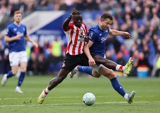 Brian Brobbey stretches his leg across James Tarkowski to protect the ball as he heads towards goal