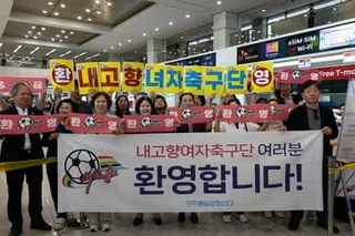 Group of people holding up giant banner in airport