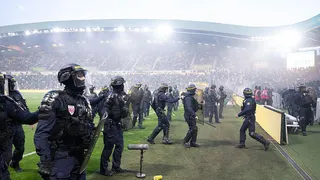 Anti-riot police officers secure the pitch after Nantes' supporters threw smoke flares and invaded it during the French L1 football match between FC Nantes and Toulouse