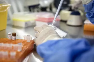 A technician demonstrates transferring cell samples in a research lab