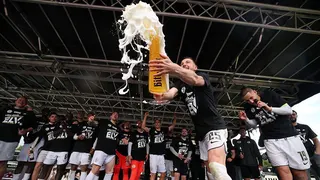 Elversberg players celebrate promotion as a giant beer glass is hoisted