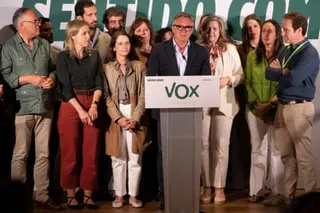 Gavira speaking at a Vox lectern, surrounded by people