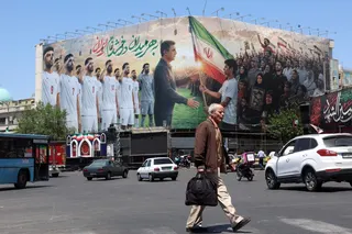 An Iranian man walks past a huge billboard supporting Iran’s national football team in the upcoming 2026 World Cup, installed on a building at Enghelab Square in Tehran on May 18, 2026. Iran’s national football team was headed to Turkey on Monday to play a final friendly match and apply for visas to fly to the United States for the 2026 World Cup, Iranian media reported. — AFP pic
