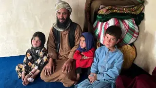 Imogen Anderson/BBC Abdul Rashid Azimi  sits on the floor looking visibly sad with three of his children.