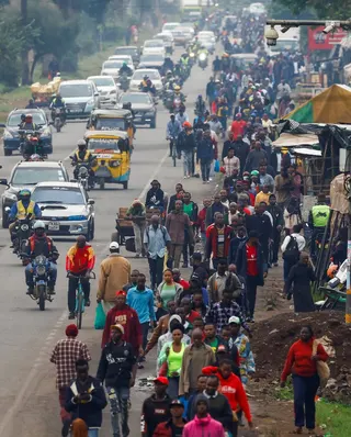 Commuters walk as private motorists drive along a Nairobi road during a public transport strike on Monday. Photo: Reuters