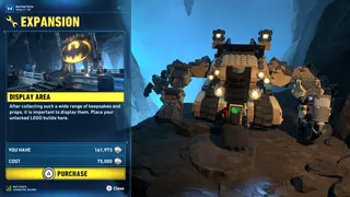 Lego Batman: Legacy of the Dark Knight screenshot showing Batman interacting with a large machine with the option to expand the Batcave area