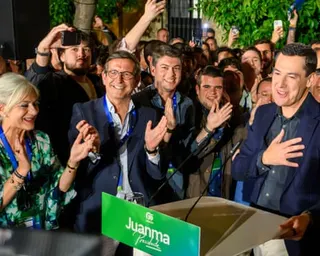 People clapping as Moreno speaks at a podium, holding a hand to his chest