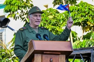 a man holds a flag while speaking into a microphone