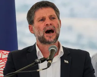 Smotrich speaks into a microphone at an event