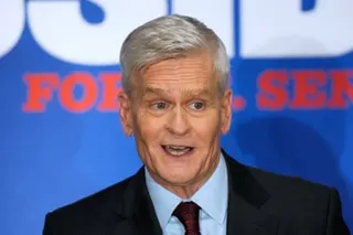 Headshot of man in suit with blue campaign promo as backdrop