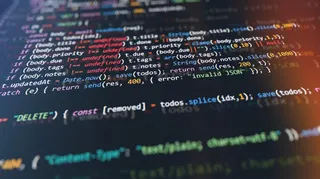 Macro shot of computer monitor displaying colorful programming code lines.