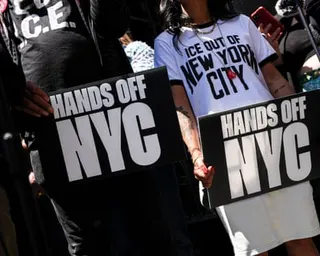 Protesters hold Hands Off NYC signs