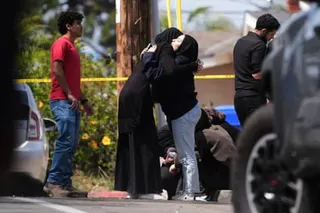 People embrace near the scene of a shooting