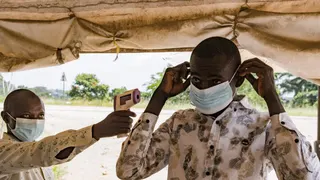 Un agent de santé frontalier au poste-frontière de Busunga, entre l'Ouganda et la RD Congo, contrôle la température d'un voyageur à l'aide d'un thermomètre infrarouge sans contact, le 18 mai 2026