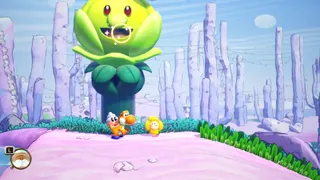 Yoshi and the Mysterious Book screenshot showing an orange Yoshi in front of a large green flower with a face on it