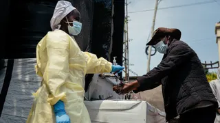 A visitor washes his hands before entering Kyeshero Hospital at a checkpoint for hand washing and temperature screening for all visitors and patients entering Kyeshero Hospital.