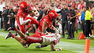 Cincinnati quarterback Brendan Sorsby leaps over Nebraska defensive back Malcolm Hartzog Jr. to score a touchdown.