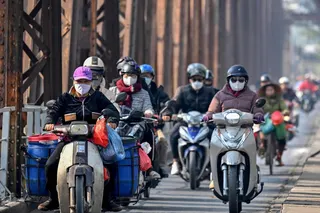 Motorists wearing face masks ride motorbikes and scooters along Long Bien Bridge amid heavy air pollution in Hanoi on January 3, 2025. — AFP pic