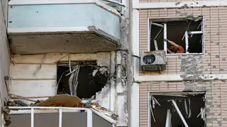 Varios residentes retiran cristales rotos en un edificio de apartamentos dañado tras un ataque ucraniano con drones en el transcurso del conflicto entre Rusia y Ucrania, en Krasnogorsk, en la región de Moscú, Rusia, el 17 de mayo de 2026.