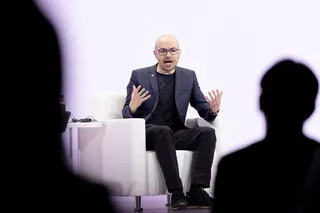 Demis Hassabis speaks while seated on a stage