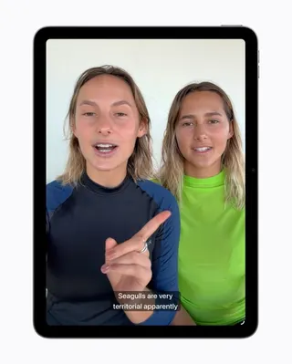 A video frame on iPad shows two people speaking, with generated subtitles appearing at the bottom of the screen.