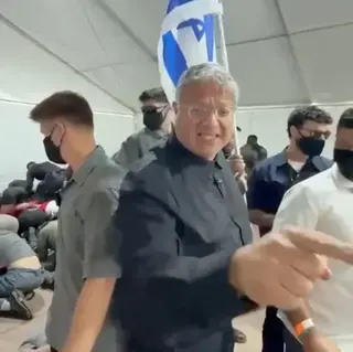 Office Of Itamar Ben Gvir/Handout via Reuters Israeli National Security Minister gestures in front of an Israeli flag while touring  a facility in the Israeli port of Ashdod where pro-Palestinian activists from a Gaza-bound flotilla are being detained (20 May 2026)
