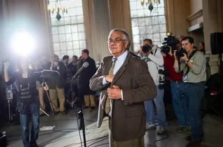 a man stands as people point cameras in his direction