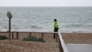 Police officer guards Brighton Beach site where three women were recovered from the sea