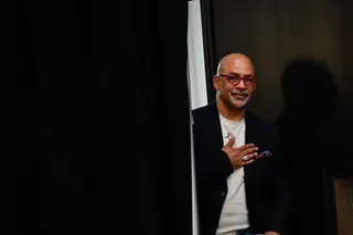 a man stands with his hand over his chest